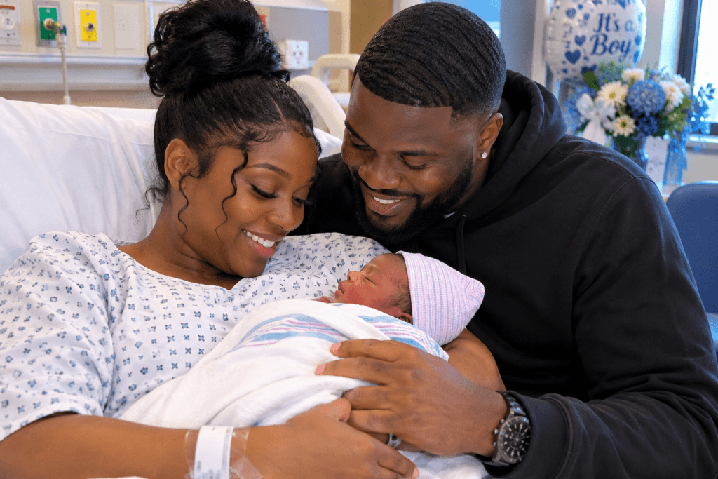 New parents smiling at their newborn baby